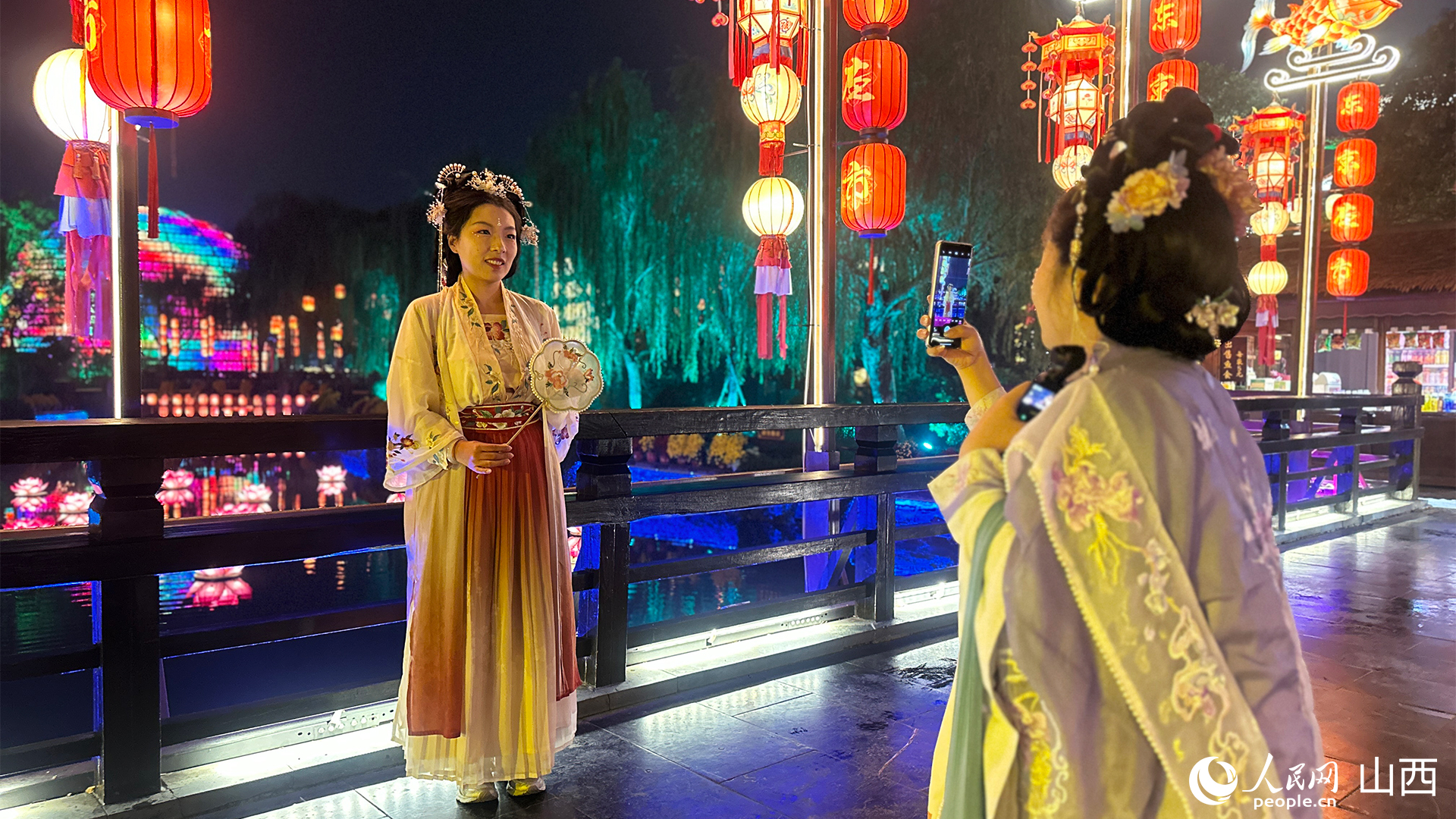 游客穿著宋制漢服在清明上河園景區(qū)打卡拍照。人民網(wǎng)記者 董童攝