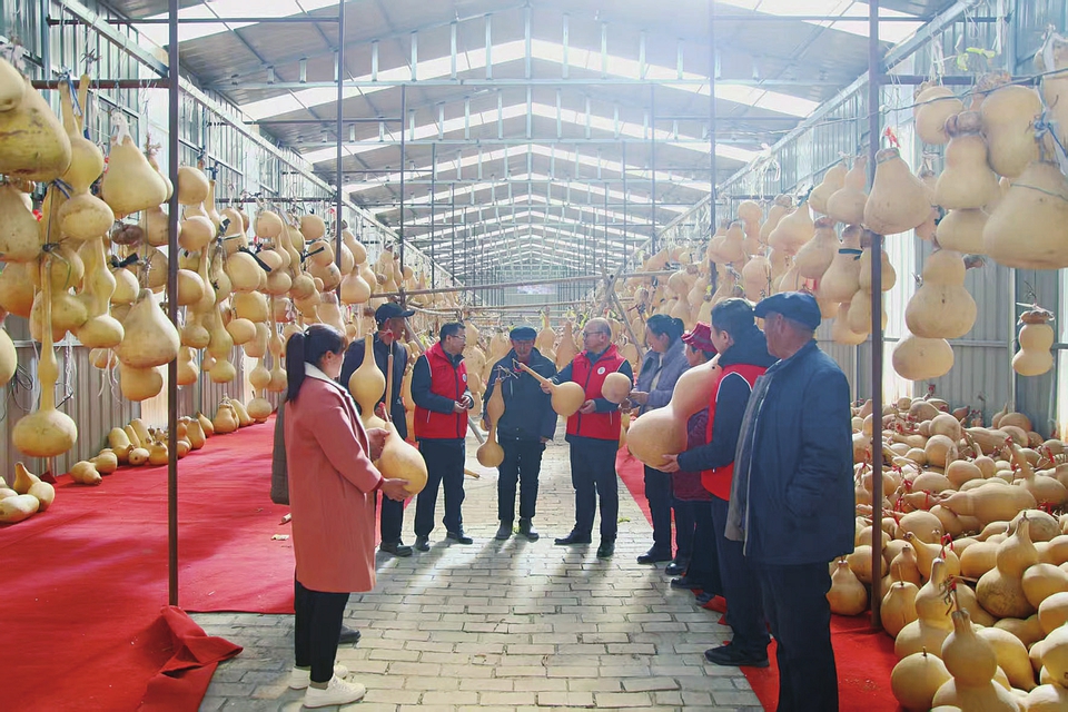 呂梁市委政法委駐興縣蔡家會鎮(zhèn)獅子洼村第一書記和工作隊隊員與村民劉俊連交流葫蘆雕刻藝術(shù)。
